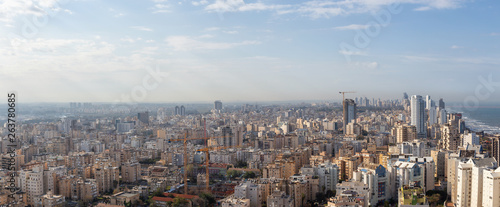 Aerial view of a residential neighborhood in a city during a cloudy and sunny sunrise. Taken in Netanya, Center District, Israel.