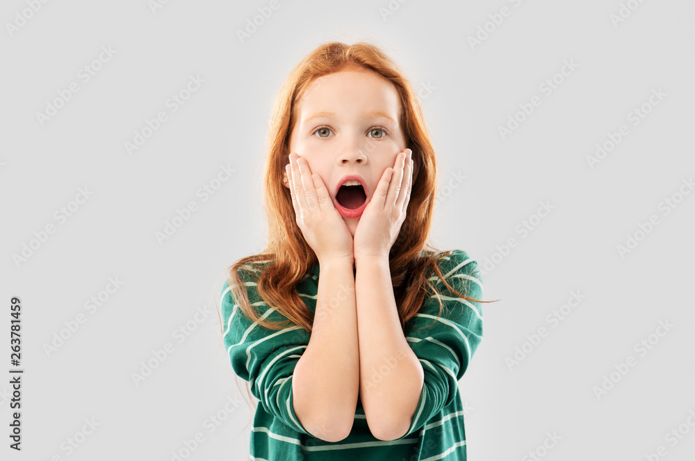 emotion, expression and people concept - shocked or surprised red haired girl in green striped shirt with open mouth over grey background emotion, expression and people concept - shocked or surprised red haired girl in green striped shirt with open mouth over grey background