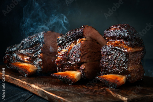 Photo Cut a large piece of smoked beef brisket to the ribs with a dark crust