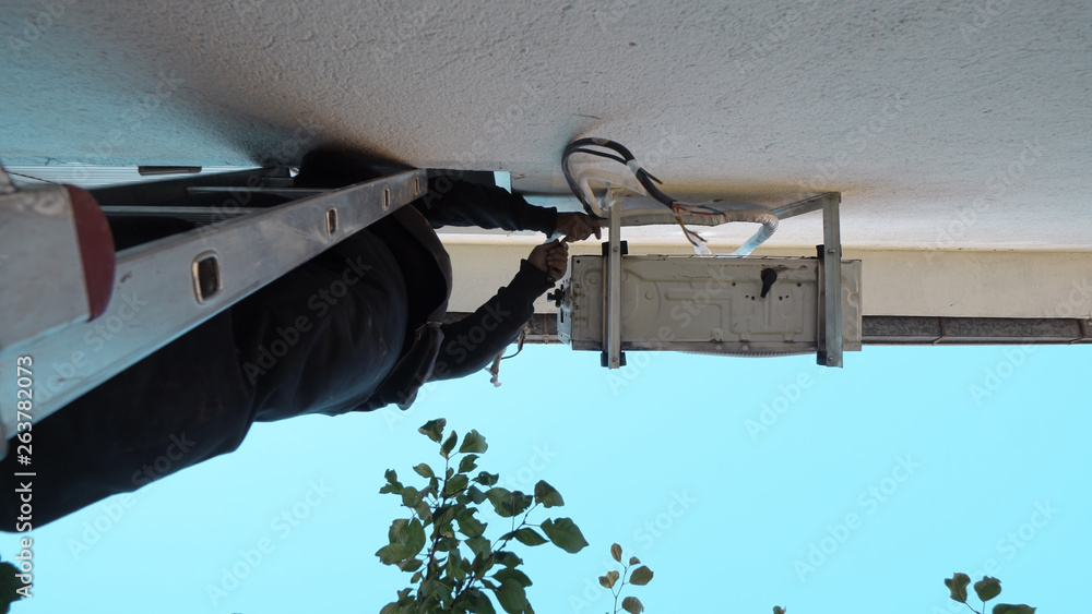 Obraz premium Technician repairing air conditioner on the wall