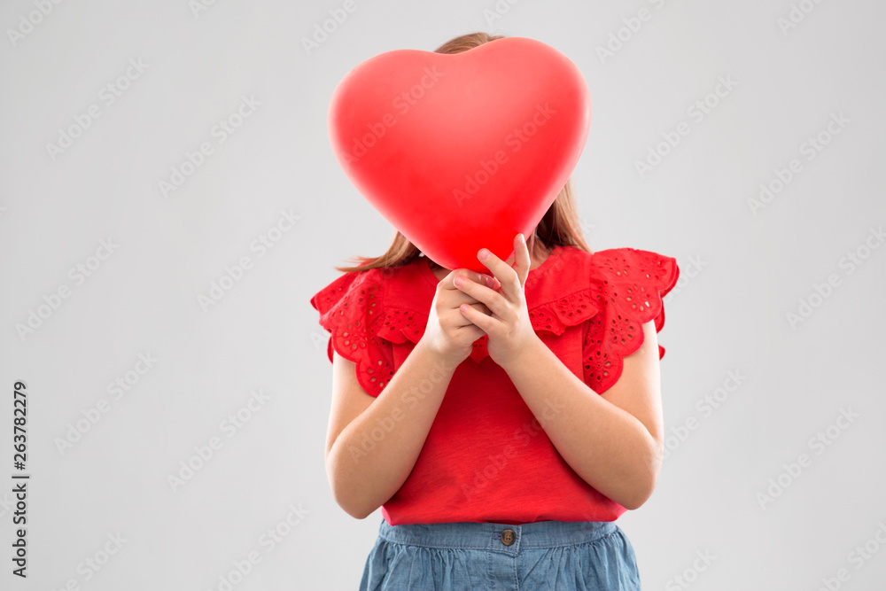 valentines day and love concept - girl hiding behind heart shaped balloon over grey background valentines day and love concept - girl hiding behind heart shaped balloon over grey background