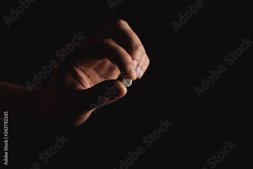 pills in hand on black background © callisto