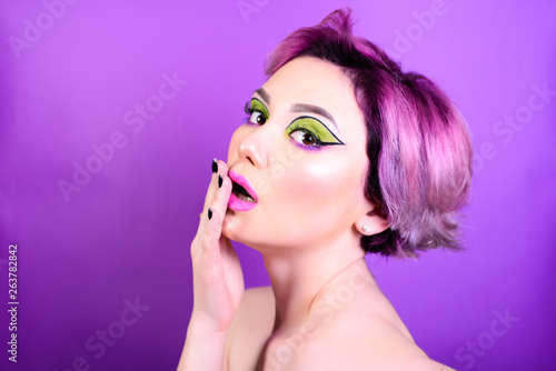 Shock reaction. Sexy girl with short hair. Portrait of a woman with bright colored hair, all shades of purple. Beautiful lips and makeup. . Professional coloring. professional makeup.