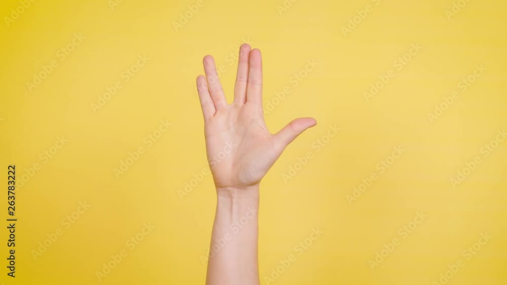 Hand makes vulcan salute against yellow backdrop. Hand makes vulcan salute against yellow backdrop.