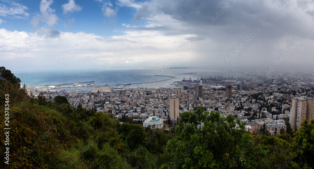 Beautiful panoramic view of a city on the coast of Mediterranean Sea during a cloudy day. Taken in Haifa, Israel.