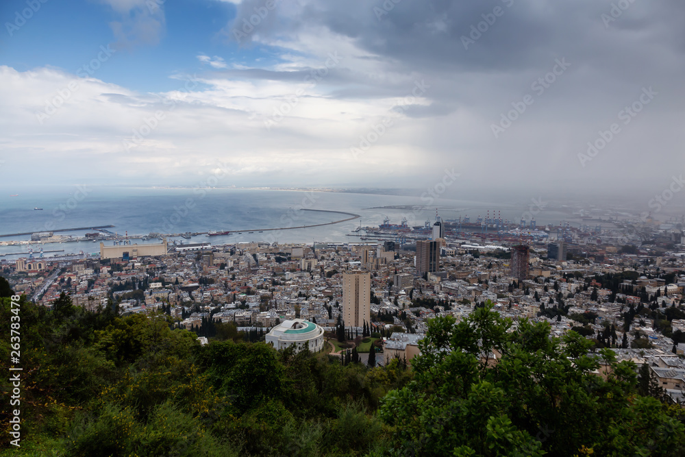 Beautiful view of a city on the coast of Mediterranean Sea during a cloudy day. Taken in Haifa, Israel.
