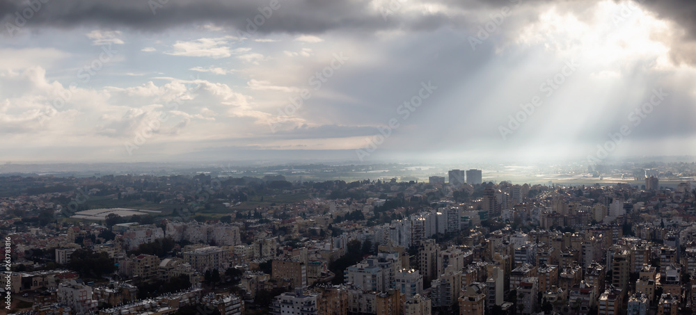 Obraz premium Aerial panoramic view of a residential neighborhood in a city during a cloudy sunrise. Taken in Netanya, Center District, Israel.