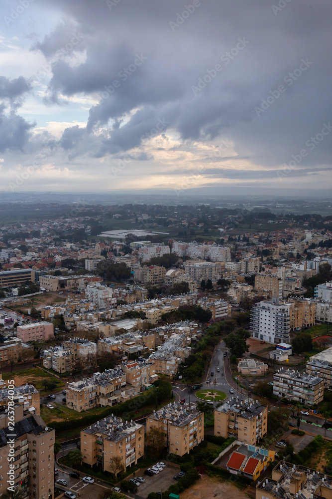 Aerial view of a residential neighborhood in a city during a cloudy sunrise. Taken in Netanya, Center District, Israel.