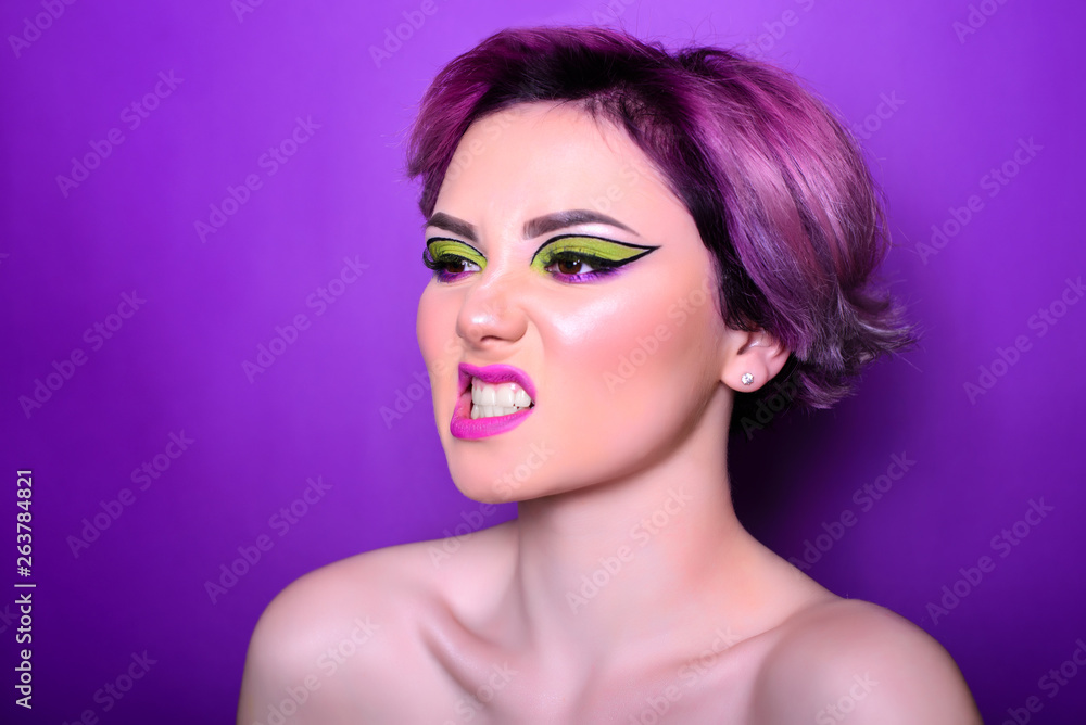 Sexy girl with short hair. Portrait of a woman with bright colored hair, all shades of purple. Beautiful lips and makeup. express anger with your face. Professional coloring. professional makeup.