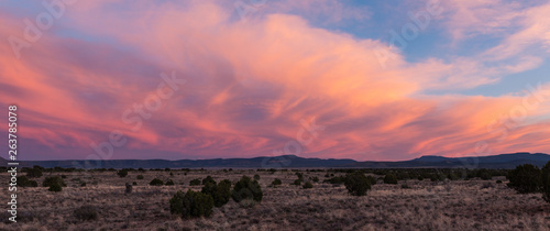 Sunset illuminates swirling dramatic clouds over the desert along Route 66 in Arizona