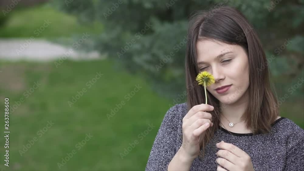 Beautiful Young Woman Holding a Yellow Flower in the Park, Slow Motion Shot Beautiful Young Woman Holding a Yellow Flower in the Park, Slow Motion Shot