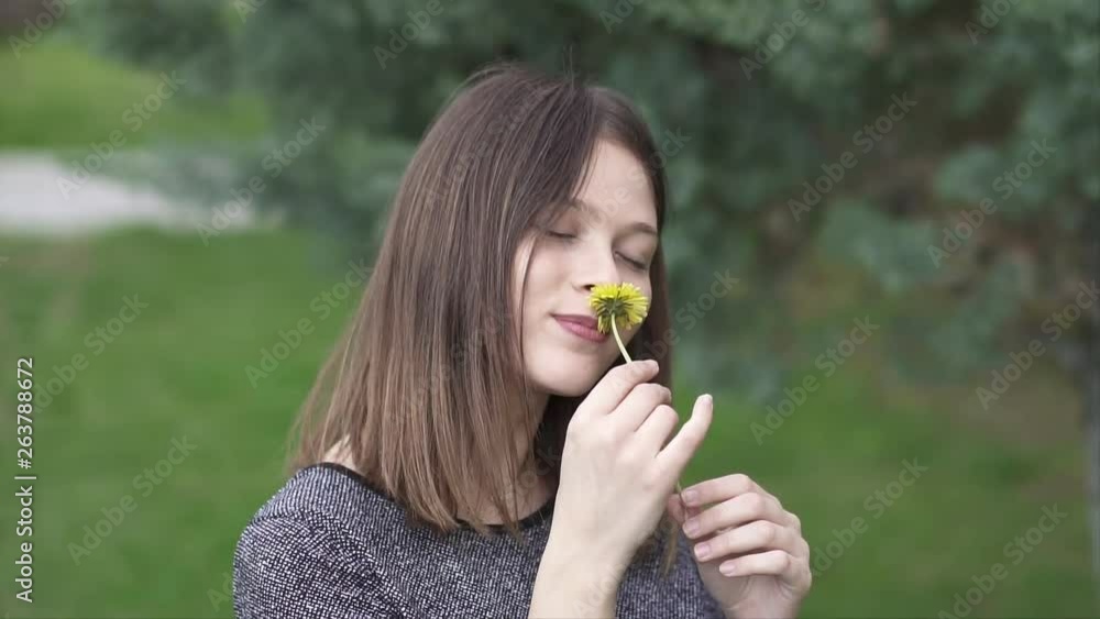 Beautiful Young Woman Holding a Yellow Flower in the Park, Slow Motion Shot Beautiful Young Woman Holding a Yellow Flower in the Park, Slow Motion Shot