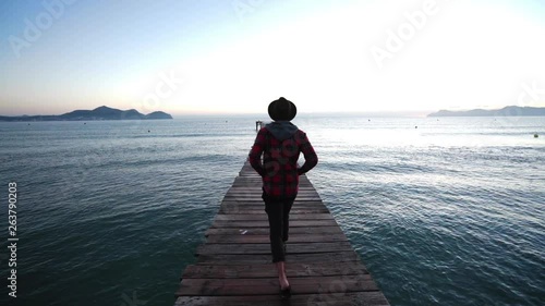 Guy walks down a bridgte to the Sea of Mallorca photo