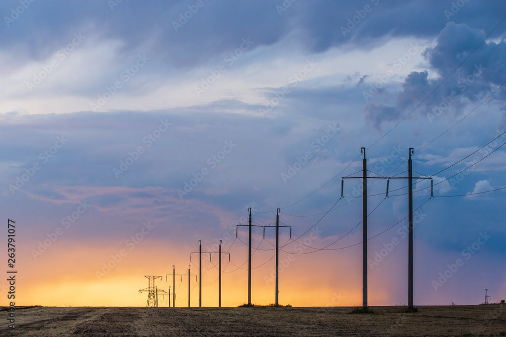 Rural landscape with high-voltage line on sunset