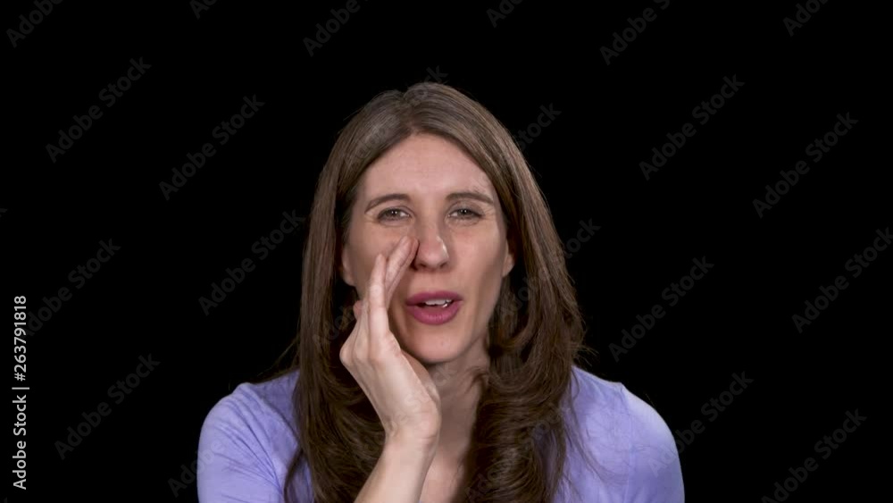 Close-up of a brunette woman gesturing for the viewer to come closer then she tells a secret Close-up of a brunette woman gesturing for the viewer to come closer then she tells a secret