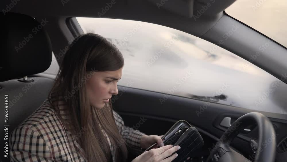 Very sexy brunette with long hair sitting in car, opening empty wallet, forgetting money and credit cards. Girl getting upset and hitting/punching the driving wheel and desperately leaning on backseat Very sexy brunette with long hair sitting in car, opening empty wallet, forgetting money and credit cards. Girl getting upset and hitting/punching the driving wheel and desperately leaning on backseat