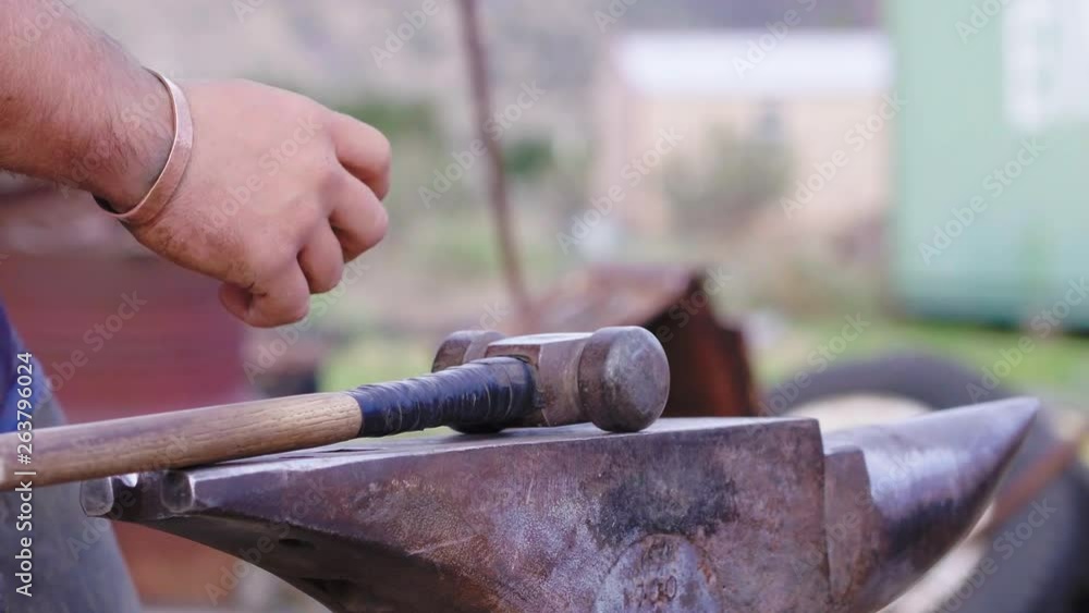 Slow motion shot of a Blacksmith, finished using his hammer and anvil on shaping a horseshoe, 23.98 fps, 4K. Slow motion shot of a Blacksmith, finished using his hammer and anvil on shaping a horseshoe, 23.98 fps, 4K.