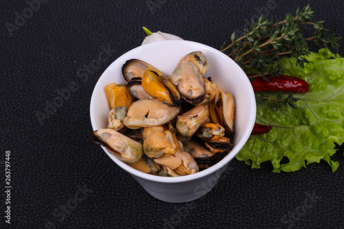 Pickled mussels in the bowl served pepper, garlic and salad