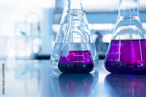 chemical purple water solution in glass flask at education science laboratory background