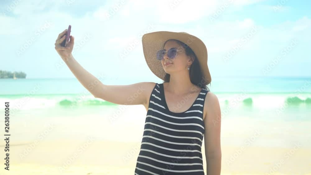 beautiful young woman taking selfie on beach. beautiful young woman taking selfie on beach.