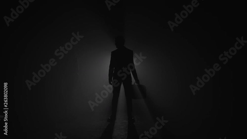 Silhouette of corrupted businessman exchanging briefcase with handshake photo