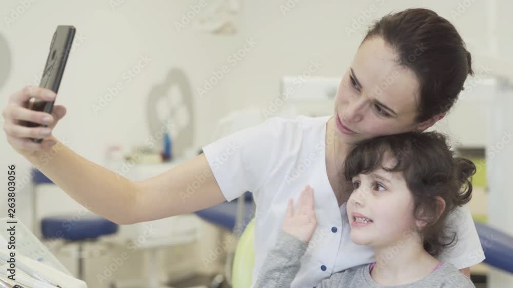 Young Girl Being Distracted With Phone While At The Dentist Young Girl Being Distracted With Phone While At The Dentist