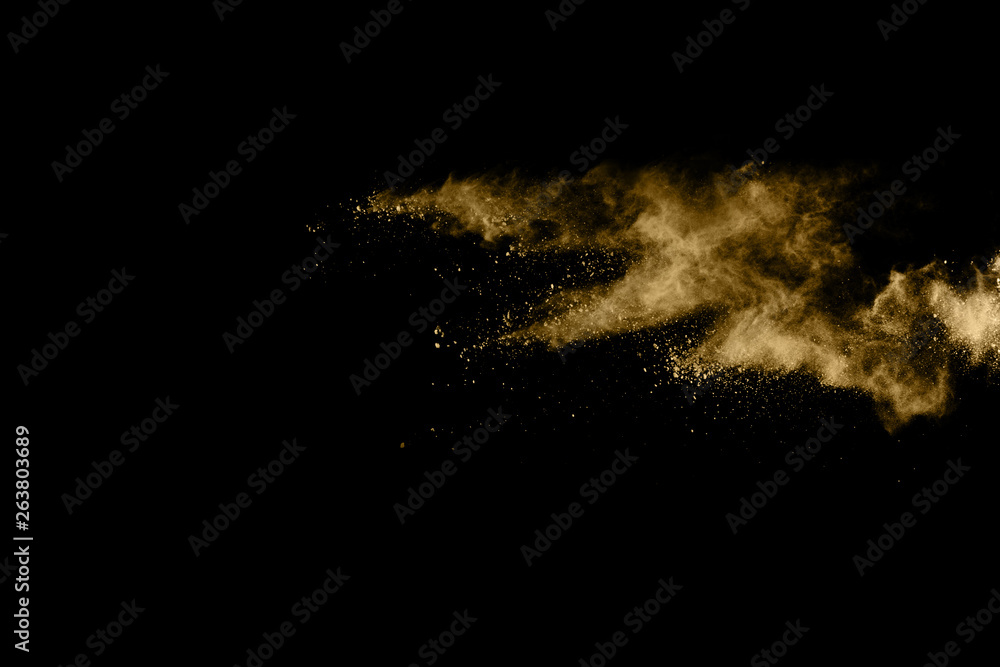 Fototapeta premium Golden powder explosion on black background. Freeze motion.