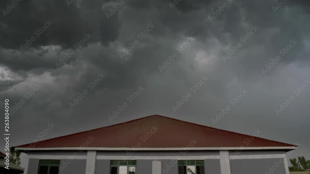 Time-lapse of a dark menacing storm rolling in the sky above a single building. Time-lapse of a dark menacing storm rolling in the sky above a single building.