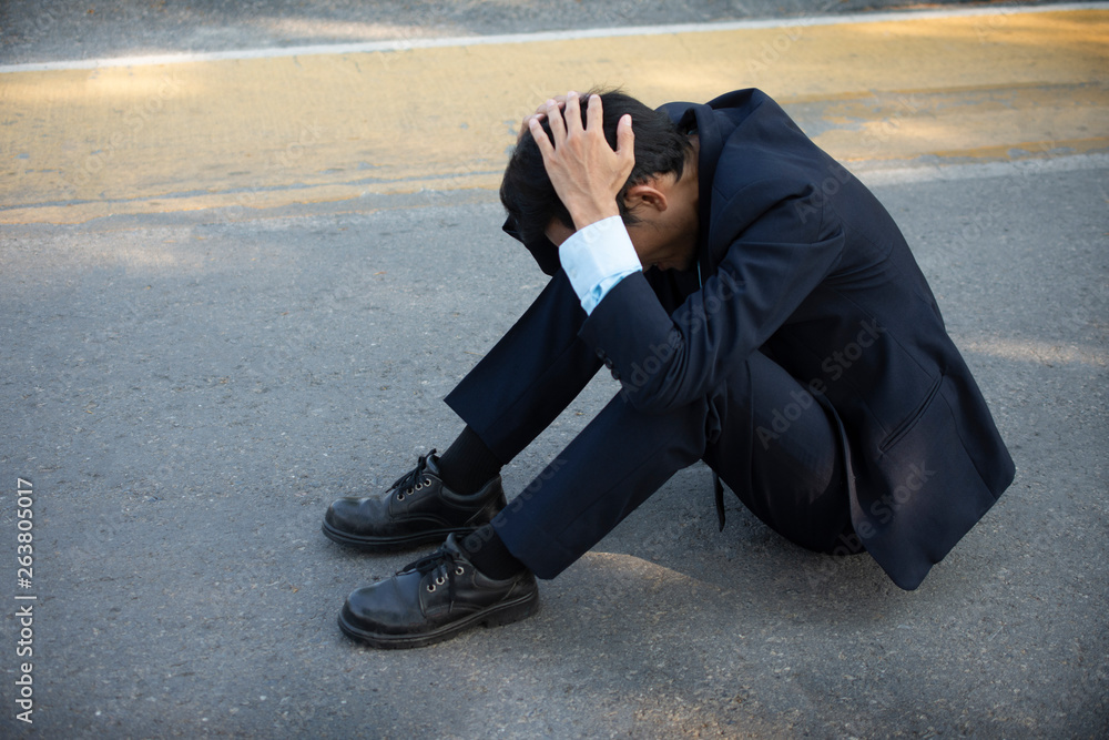 Disappointed Businessman sitting on road,He Sad in life And business failure Disappointed Businessman sitting on road,He Sad in life And business failure