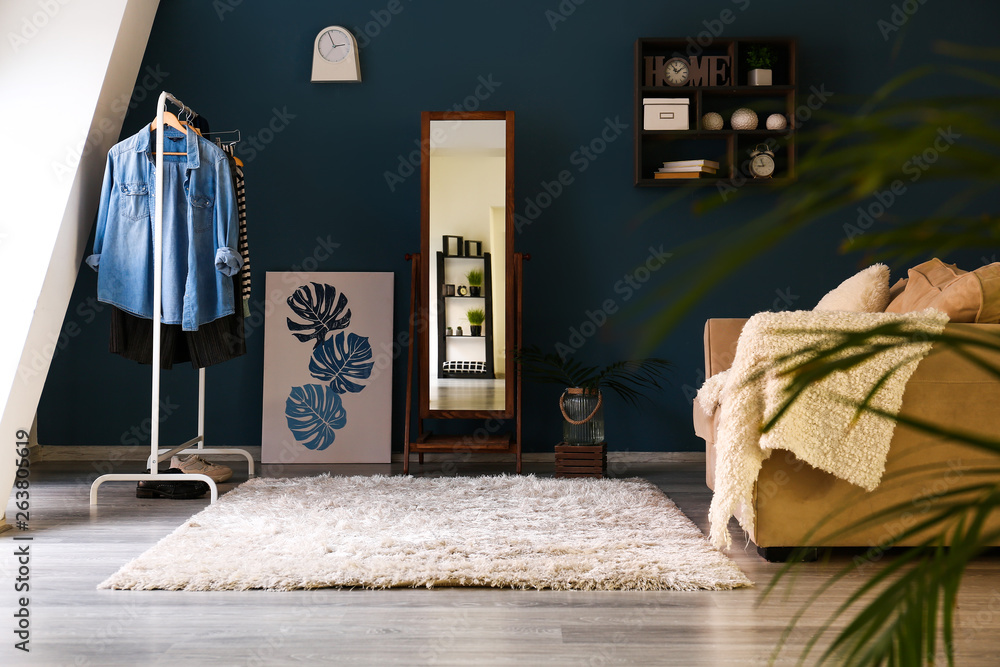 Big mirror with female clothes in interior of room