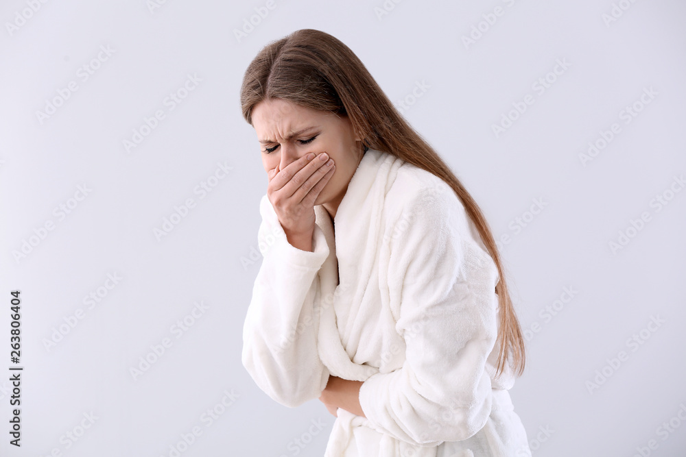 Pregnant woman suffering from toxicosis on light background Pregnant woman suffering from toxicosis on light background