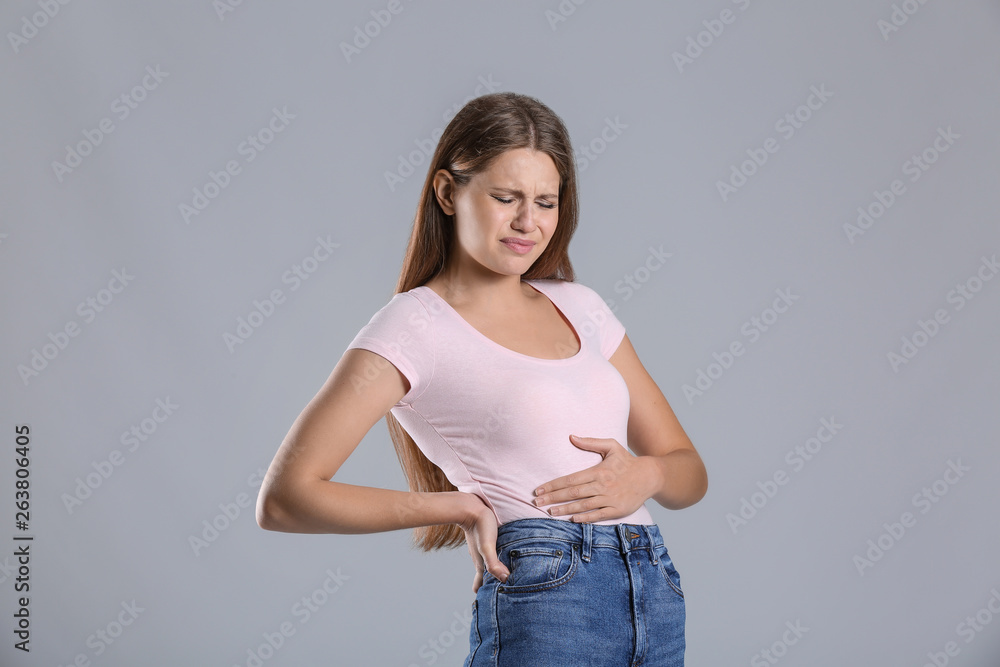 Pregnant woman suffering from toxicosis on grey background Pregnant woman suffering from toxicosis on grey background