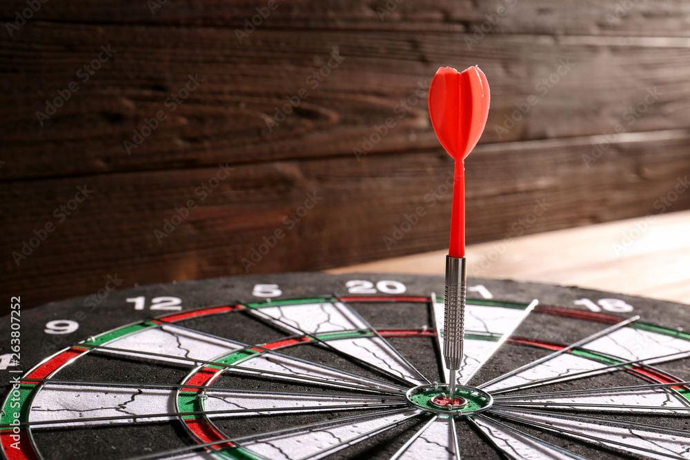 Dartboard with hit bullseye on table, closeup Dartboard with hit bullseye on table, closeup