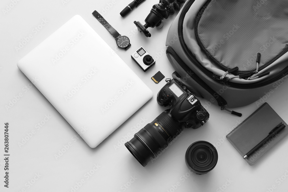 Modern equipment of professional photographer with laptop on light background - obrazy, fototapety, plakaty 