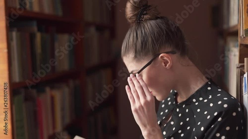 University Female Caucasian College Student Checking Out Book in Public Library 1 photo