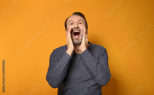 Portrait of screaming mature man on color background