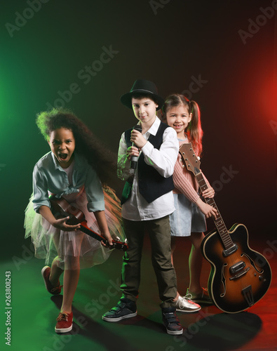 Band of little musicians on dark background
