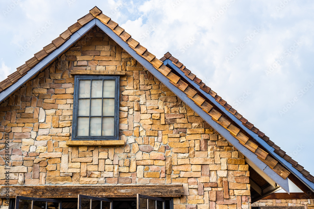 Classic roof decorated with stone and wood in vintage style. Traditional building