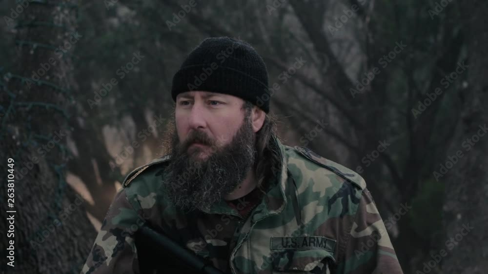 Medium shot of a man wearing camouflage, holding a weapon & listening for wildlife in the woods, 29.97 fps. Medium shot of a man wearing camouflage, holding a weapon & listening for wildlife in the woods, 29.97 fps.