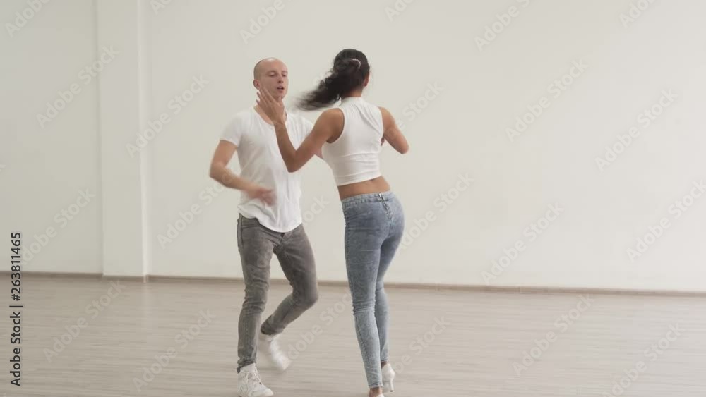 Dancing couple having fun practicing a series of quick twirls and spins in a dance studio. Dancing couple having fun practicing a series of quick twirls and spins in a dance studio.