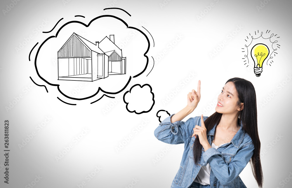 Young asian business woman thinking isolated on white background.Dreaming about new house. Thoughtful young woman looking at the sketch on the wall while Young asian business woman thinking isolated on white background.Dreaming about new house. Thoughtful young woman looking at the sketch on the wall while