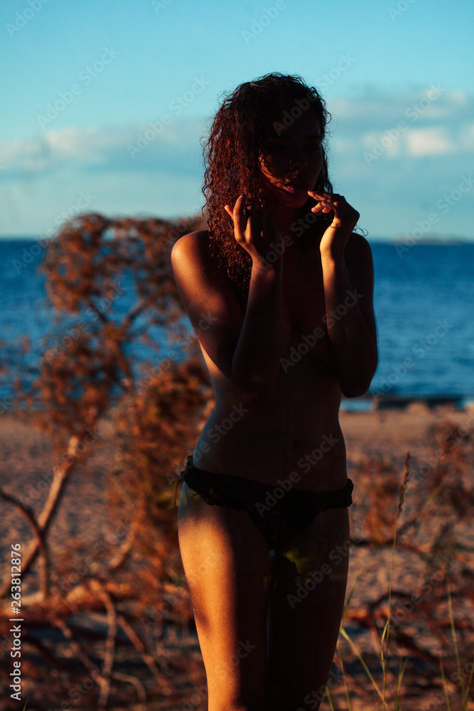 young pretty african curly girl on sunset on beach sexy looking, lifestyle people concept