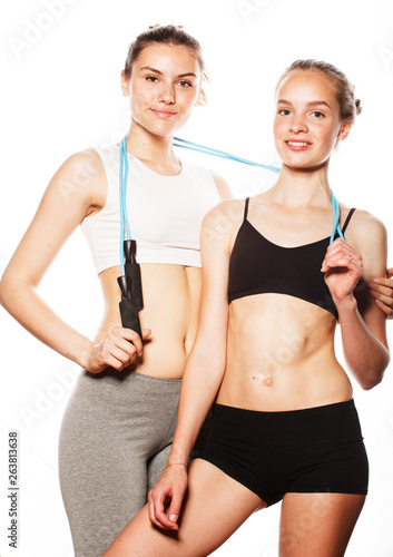 two sport girls measuring themselves isolated on white