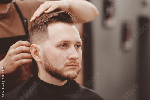 Barbershop banner. Man in barber chair, hairdresser styling his hair.