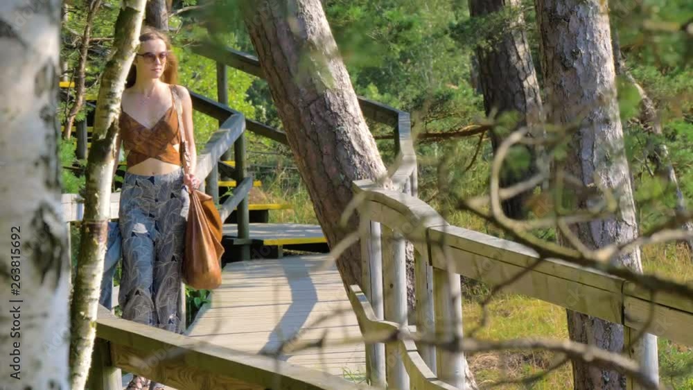 Caucasian woman walking through a path in the forest Caucasian woman walking through a path in the forest