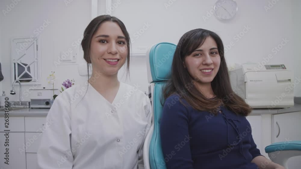 Dentist and patient siting and looking at the camera with a smile. Dentist and patient siting and looking at the camera with a smile.