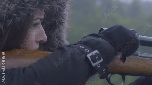 Close up side profile of a woman cocking a rifle handle, 30 fps.