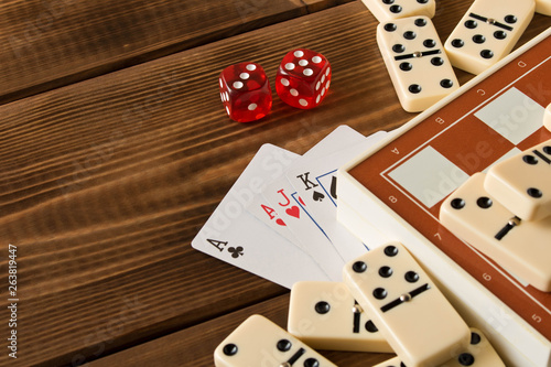 Chess, playing cards, dominoes on a wooden table. The concept of Board games.