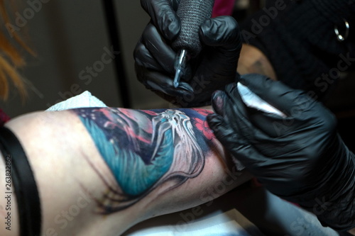 Tattoo master makes a client a colorful tattoo © Anton Petukhov