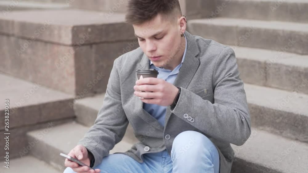 Well dressed business man sipping coffee and checking his phone. Well dressed business man sipping coffee and checking his phone.